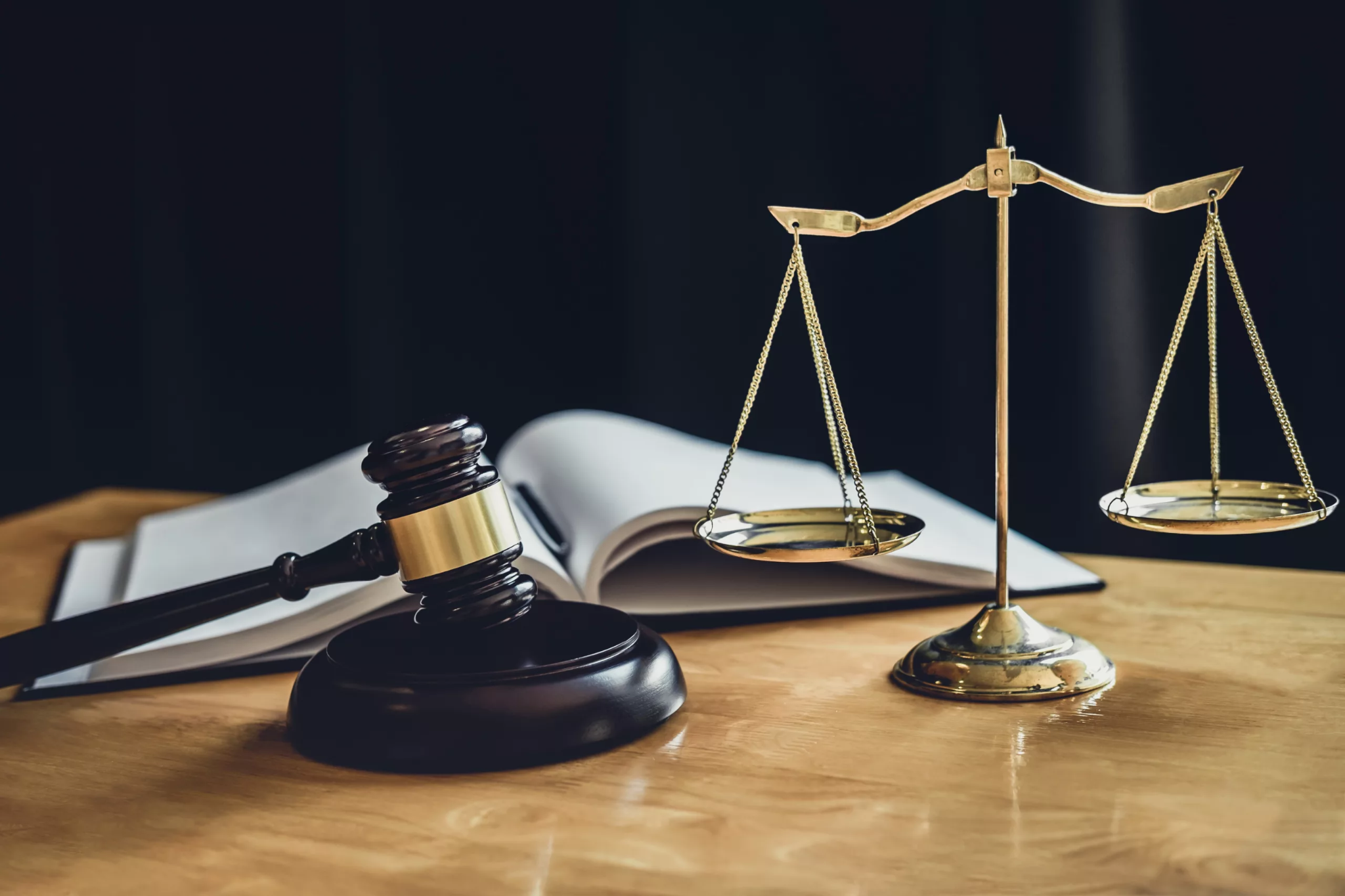 Imagem de um martelo da justiça, balança dourada e livro aberto